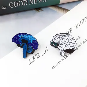 Dettaglio di spille in smalto a forma di cervello blu e bianco su sfondo di libro