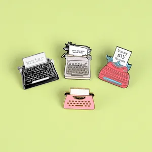 Detailed view of four vintage typewriter enamel pins in assorted retro pastel colors