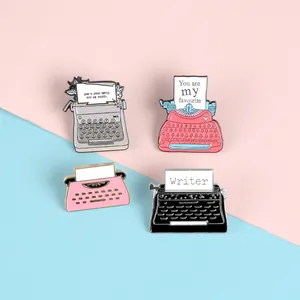 Set of retro typewriter enamel pins with floral details and inspirational phrases
