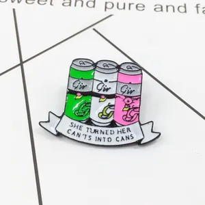 Vue macro d'un pin's émaillé de canettes colorées avec ruban de texte motivant