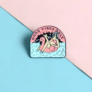 Detalle del broche de esmalte Good Vibes con una mujer en un flotador de flamenco
