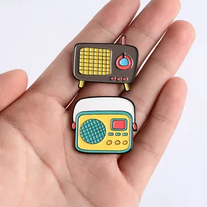 Détail de broches en émail radio rétro sur une main montrant la taille et la texture