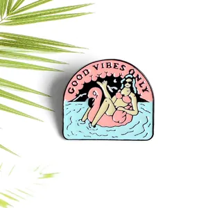 Broche esmaltado de chica en flotador flamenco con mensaje Good Vibes Only