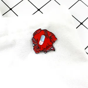 Detail of a red enamel jacket brooch with a capsule icon pinned on white canvas