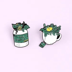 Detail view of enamel pins featuring a medicine pot and tea cup with plants