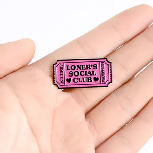Spilla in smalto rosa Loner's Social Club tenuta in mano per mostrare la dimensione reale