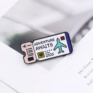 Vue macro d'un pin's ticket d'avion émaillé avec Adventure Awaits et motif d'avion