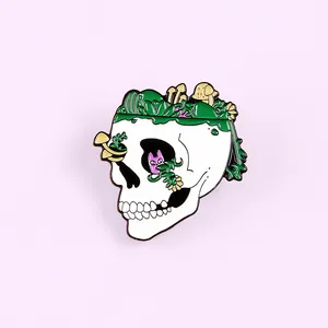Detail of skull enamel pin with green plants, mushrooms and pink cat on pastel background