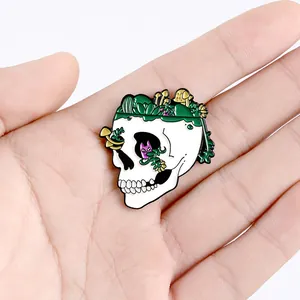 Cartoon skull enamel pin with green succulents and yellow mushrooms on a white base