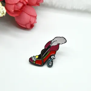 Christmas red high heel brooch with gray feathers and enamel finish on white fur background