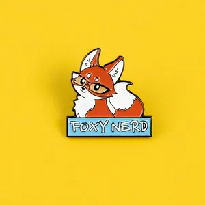 Detail shot of the FOXY NERD enamel pin featuring an orange fox with glasses on yellow background