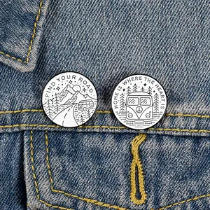 Détail de pins en émail d'aventure avec motifs de montagne et van sur veste en jean