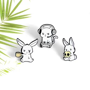 Close-up of three enamel pins featuring a gaming cat, bunny with cup, and bunny with skull