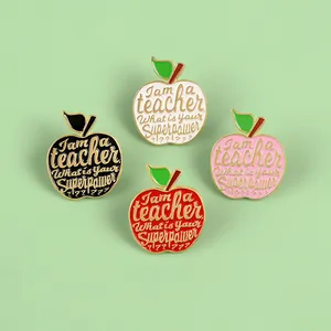Top view of four colorful apple enamel pins with inspirational teacher quotes