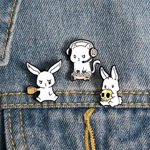 Detailed view of cute cartoon white rabbit and gaming cat enamel pins on denim jacket