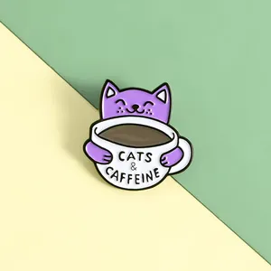 Makroaufnahme einer Emaille-Brosche mit Katze und Cats and Caffeine Schriftzug