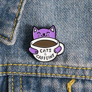 Detail der Emaille-Anstecknadel mit Katze und Kaffee auf Jeansjacke mit Cats & Caffeine Text