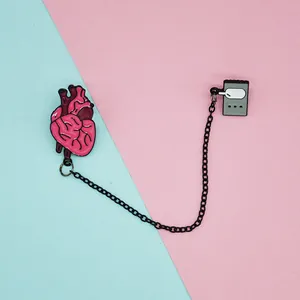 Detailed close-up of connected heart and pager alloy brooches with metal chain links