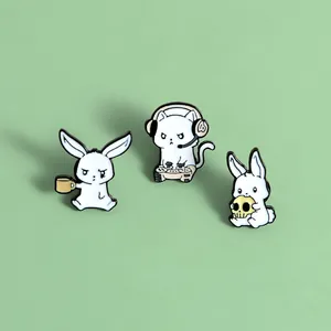 Detailed view of white enamel pins featuring cartoon rabbit and gaming cat designs