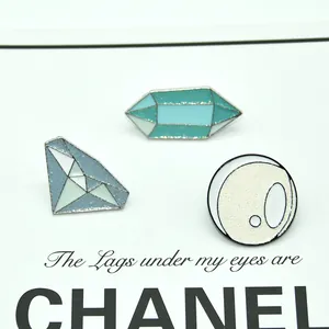 Detailed view of three crystal ball brooches with glitter finish and metallic base
