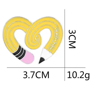 Creative heart-shaped yellow pencil enamel pin featuring Make More Art text design