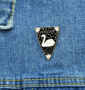 Cartoon white swan enamel brooch with Forever text on blue denim jacket