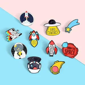 Lot de 10 pin's en émail coloré avec fusées et astronautes sur fond bicolore rose et bleu