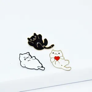 Three cute cartoon enamel cat pins including a white kitty holding a red heart accessory