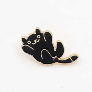 Detailed view of a playful black cat enamel brooch with polished gold-plated edges