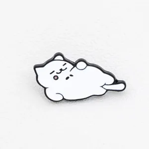 Macro shot of cute white enamel cat brooch with pink blush and lazy lying pose