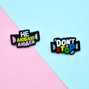 Detail von Emaille-Anstecknadeln mit russischem Text und Don't Stop Slogan auf buntem Grund