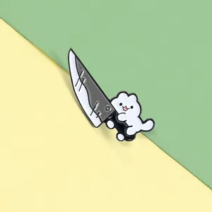 Close-up of a cute white cat enamel pin holding a large knife on a split pastel background