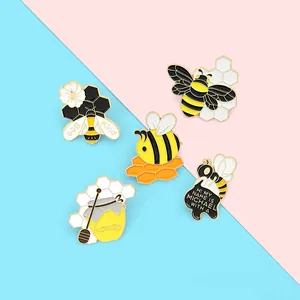 Set of five cute honey bee enamel pins with honeycomb designs on a colorful background