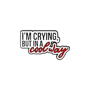 Détail du pin's émaillé avec le slogan I'M CRYING BUT IN A COOL WAY sur fond blanc uni
