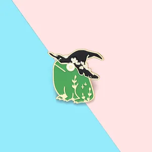 Detail of green witch frog enamel pin featuring a black hat and gold outlines