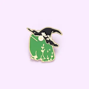 Cute green witch frog enamel pin with black wizard hat and golden floral patterns