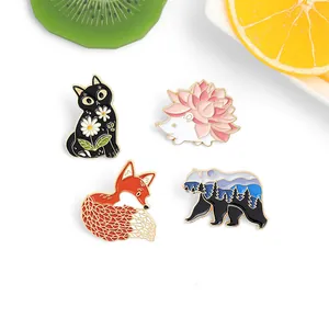 Detail of four enamel animal pins featuring a cat, hedgehog, fox, and bear with fruit accents