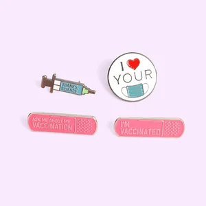 Set of four medical enamel pins featuring a syringe, mask, and band-aids on lavender