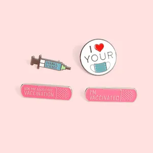Set of four pink enamel badges featuring heart mask, syringe, and vaccination theme