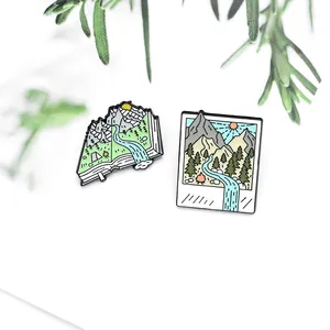 Detail of creative outdoor nature enamel pins featuring mountain landscapes and forest books