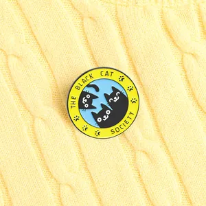 Broche ronde émaillée mignonne Black Cat Society sur fond de pull en maille jaune