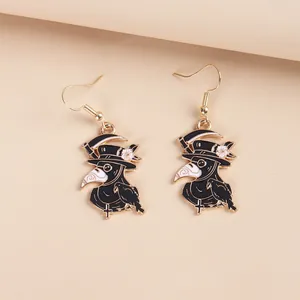Detail of gothic plague doctor earrings with black and white enamel and golden base