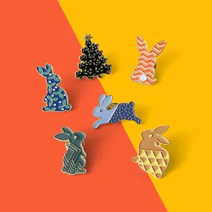 Détail de pins en émail montrant un lot de lapins et un sapin de Noël en forme de chat