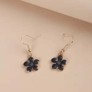 Close-up of elegant flower drop earrings with black marble petals and golden hooks