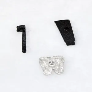 Back view of cute tooth toothpaste and toothbrush enamel pins with metal texture