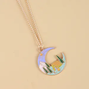 Gold crescent moon pendant necklace with mountain forest and cabin landscape scene