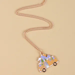 Macro detail of retro enamel bus pendant with snowy mountain and golden link chain