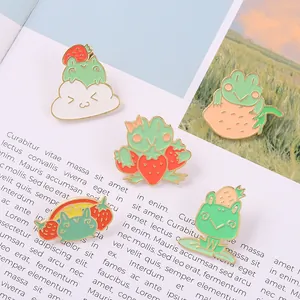 Detailed set of cute green frog enamel pins with strawberry and rainbow on a magazine