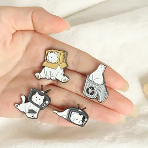 Detalle de pines esmaltados con gato televisor y motivos de oso polar en aleación de zinc