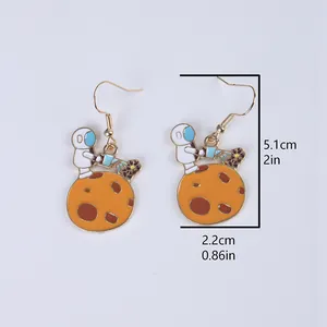 Detail view of astronaut earrings with size labels 5.1cm by 2.2cm on grey background